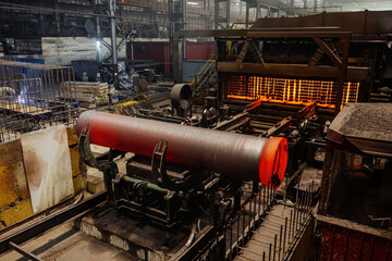 Freshly cast red hot iron pipe at the foundry, new pipe is cooling down