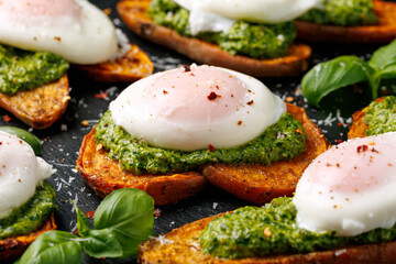 Sweet potato toast with green pesto and egg Benedict. Vegetarian protein food concept
