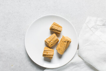 Overhead view of Nigerian Balewa candy, top view of hausa alewa candy on a white background, pulled hard sugar candy on a white countertop