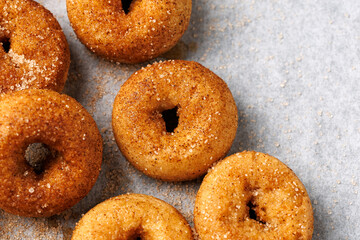 Mini cinnamon sugar donuts on baking paper.
