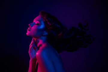 Portrait of a sensual woman in vibrant blue and pink neon lighting, showcasing modern style and...