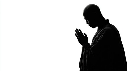 Buddhist monk in silhouette prayer position on a serene background representing peace and mindfulness