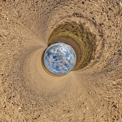 blue hole sphere or globe little planet inside grass or sand or dry ground frame background with...