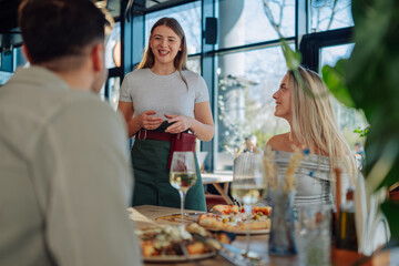 Waitress taking order from customers at restaurant table