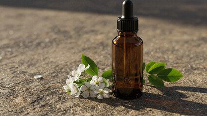 Essential oil bottle placed on stone background with flowers  