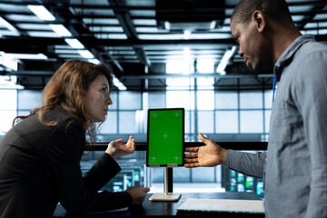 Programmers in data center brainstorming, using mockup tablet, observing analytics, reviewing...