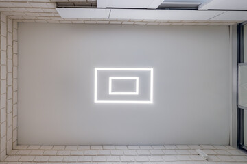 Fototapeta premium suspended ceiling with halogen spots lamps in form of squares and rectangles and drywall construction in empty room in apartment or house. Stretch ceiling white and complex shape.