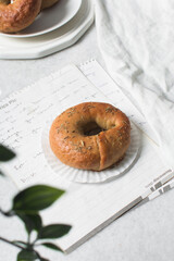 Overhead view of freshly baked bagels on white serving tray, top view of homemade bagels on white...