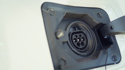 Close up shot of electric car charging port cover opened to recharge depleted battery, green energy...