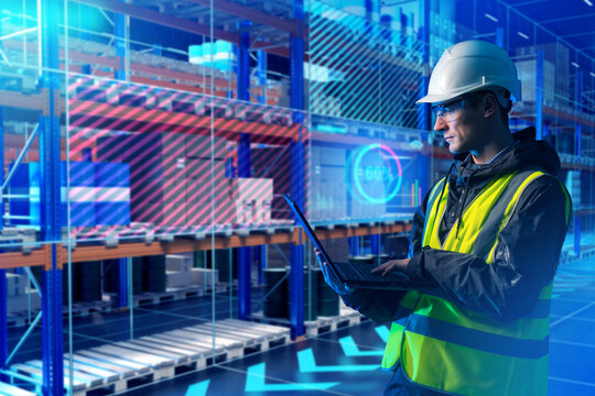 Man warehouse digitalization specialist. Programmer with laptop near rack with boxes. Warehousing software developer. Man in yellow vest in futuristic warehouse. Digitalization of storage