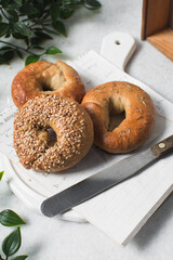 Overhead view of freshly baked bagels on white serving tray, top view of homemade bagels on white plate, process of making bagels