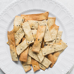 Overhead view of homemade crackers, top view of freshly baked black sesame cracker biscuits, process of making crackers