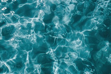 Obraz premium Water surface with blue clean refreshing texture showing pool waves and summer pattern. Sunlight reflections and tranquil outdoor mood.