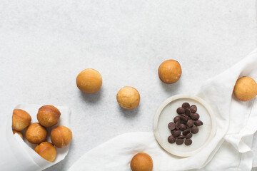 Overhead view of donut holes on a white bowl, top view of homemade doughnut holes on a white...