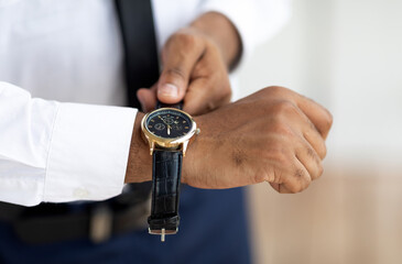Closeup of unrecognizable African American businessman wearing expensive wrist watch with leather...