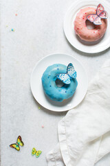 Overhead view of colorful glazed donuts on a white countertop, top view of homemade pastel doughnuts, process of making glazed doughnuts	