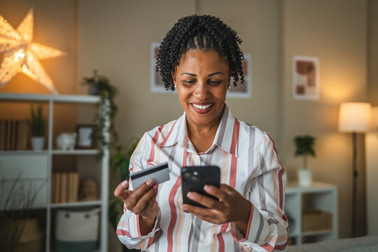 african american woman use credit card and cellphone for shopping - Powered by Adobe