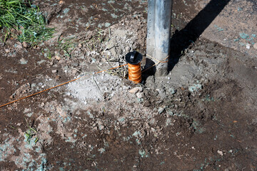 Metal post installed in cement, and leveling string, to build fence next to walkway to screen house and yard from people
