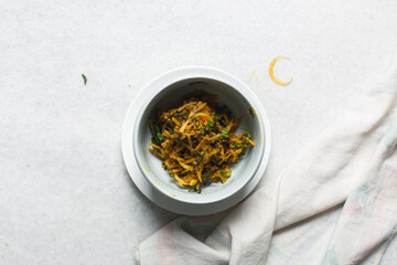 Overhead view of abacha or african salad vegetables and onions in a white plate