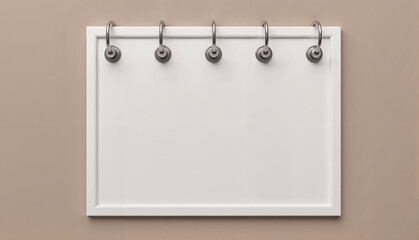 Blank white notice board with metal hooks against a soft beige background, versatile concept of office decor or event planning