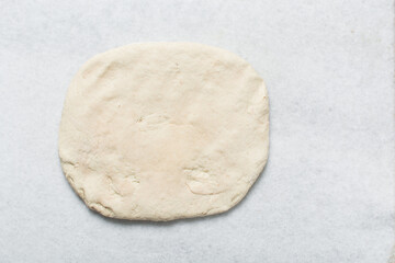 Overhead view of baozi dough being shaped on a white granite countertop, top view of mantou dough being divided on granite countertop, process of making bao bun