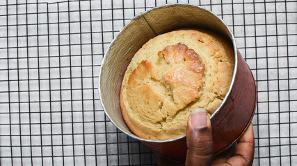 Overhead view of homemade cake in a cake pan, top view of fresh cake on countertop