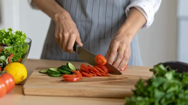 Close-Up of Woman&rsquo;s Hands Slicing Vegetables on Wooden Cutting Board for Healthy Meal Prep

