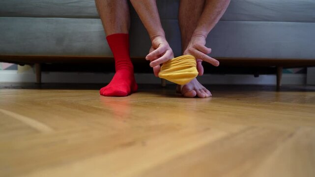 Different socks in legs. Mismatched multicolored socks on feet man. Men's legs in Different socks as symbol of down syndrome. Down syndrome awareness concept. Wear Mismatched Socks. Disabled person.