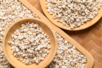 Dried Job's tears or adlay millet seeds in wooden bowl, Food ingredient, Top view