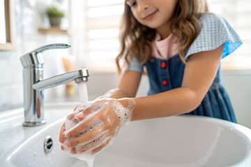 水道で手を洗う女の子の上半身
