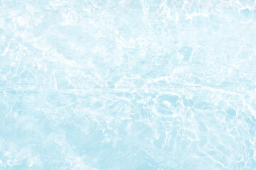 Blue water with ripples on the surface. Defocus blurred transparent blue colored clear calm water surface texture with splashes and bubbles. Water waves with shining pattern texture background.