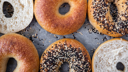 Freshly baked bagels arranged on a tray showcasing various toppings in a bright kitchen setting.