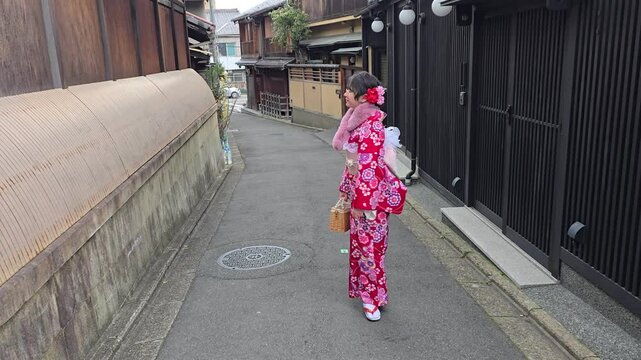 A pretty girl in a kimono. Kimono is the traditional dress worn popular in Japan. American girl posing in kimono outdoors. 