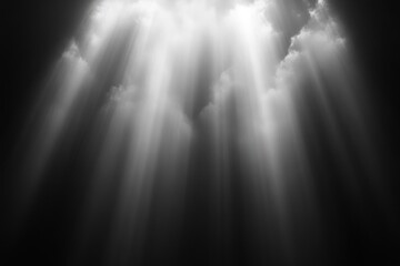 Dramatic beams of sunlight piercing through dark dense clouds creating a powerful and ethereal atmosphere