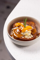 Brioche Toast with Caramel, Ice Cream and Mandarin.
Warm brioche topped with creamy ice cream, caramel sauce, mandarin slices, almond flakes and a rosemary sprig.