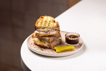 Grilled Turkey & Cheese Sandwich.
Golden toasted sandwich with layers of turkey and melted cheese, topped with herbs, served with a pickle and sweet dipping sauce.