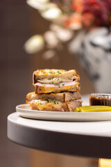 Grilled Turkey & Cheese Sandwich.
Golden toasted sandwich with layers of turkey and melted cheese, topped with herbs, served with a pickle and sweet dipping sauce.