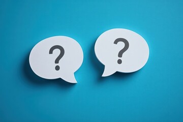 Two white speech bubble cutouts with black question marks on a blue background symbolizing curiosity and inquiry