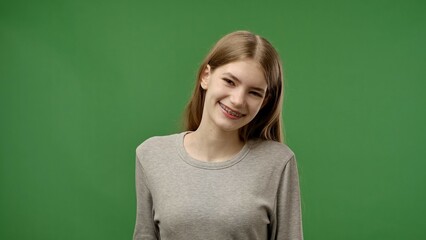 Teenage girl posing at camera smiling, positive expression, isolated on chroma key green screen...