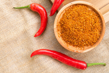Powder and fresh red chili are served on top of burlap fabric