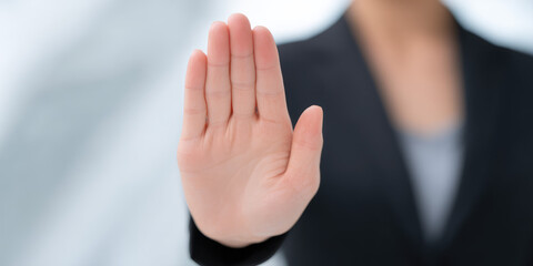 Obraz premium A person stands with their open hand facing forward in a gesture of stopping. Concept: halt, gesture, communication