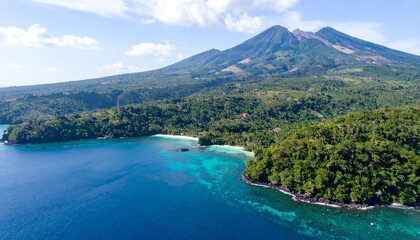 Fototapeta premium Mountainous terrain meets clear water in a vibrant coastal scenery under a bright, sunny sky