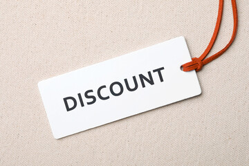 Tag with word Discount on light fabric, top view
