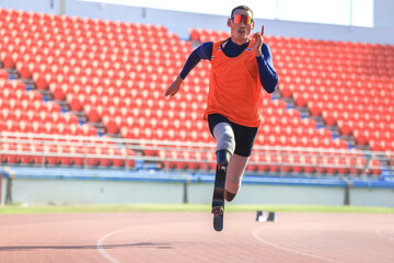 Asian para-athlete with prosthetic blades leg in stadium practicing workout for Paralympic running competition. Amputee sportsman runner practicing running workout. Disabled athlete man sport concept.