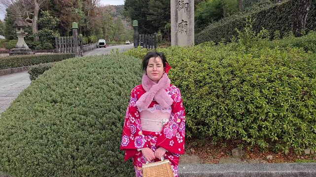A pretty girl in a kimono. Kimono is the traditional dress worn popular in Japan. American girl posing in kimono outdoors. 