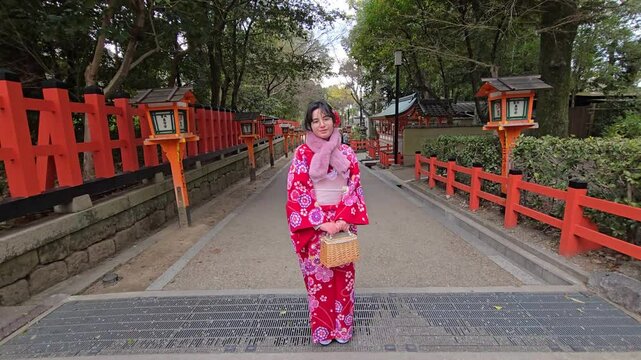 A pretty girl in a kimono. Kimono is the traditional dress worn popular in Japan. American girl posing in kimono outdoors. 