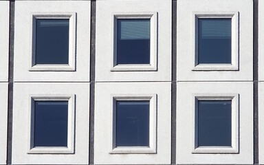 A close-up of a section of a building's facade. It features a grid of six rectangular windows arranged in two rows of three.