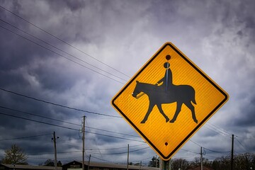 A horse rider traffic warning sign on the side of the road