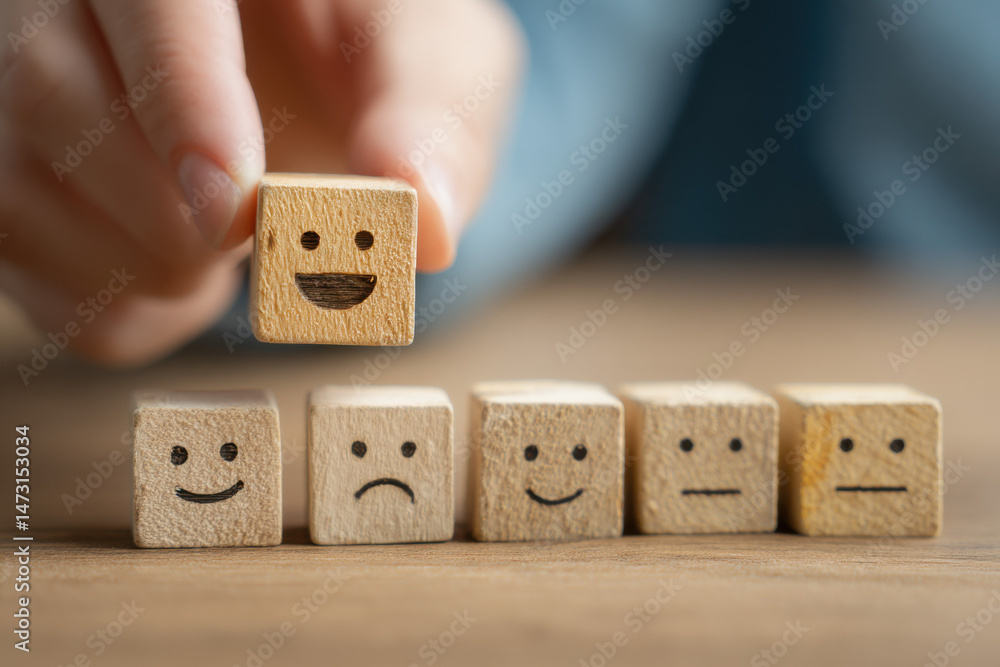 Poster hand placing a happy emoticon wooden cube above a row of mixed emotion cubes, symbolizing customer s