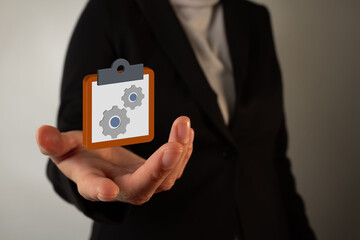 women's hand holding a 3D icon of a gear